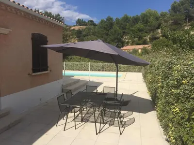 a patio with a table and chairs and an umbrella at Maison Minervois in Agel