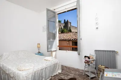 a bedroom with a bed and a large window at cote de la cite medievale in Carcassonne
