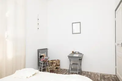 a bedroom with a white wall and a desk at cote de la cite medievale in Carcassonne