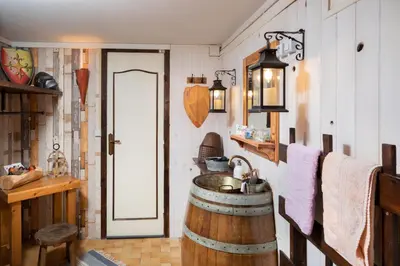 a bathroom with a wooden barrel sink and a door at cote de la cite medievale in Carcassonne