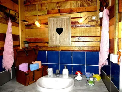 a bathroom with a sink and a wooden wall at cote de la cite medievale in Carcassonne