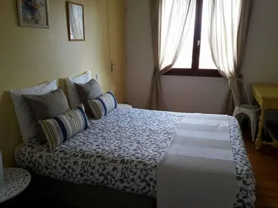 a bedroom with a large bed with pillows and a window at Gîte avec vue imprenable sur la Cité in Carcassonne
