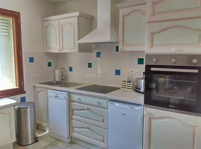 a kitchen with white cabinets and a stove top oven at Gîte avec vue imprenable sur la Cité in Carcassonne