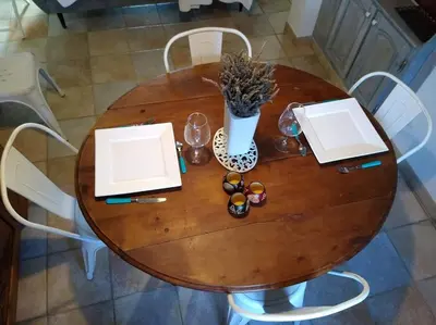 a wooden table with a vase of flowers on it at Gîte avec vue imprenable sur la Cité in Carcassonne