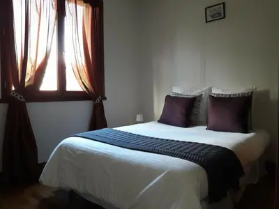 a bedroom with a bed with purple pillows and a window at Gîte avec vue imprenable sur la Cité in Carcassonne