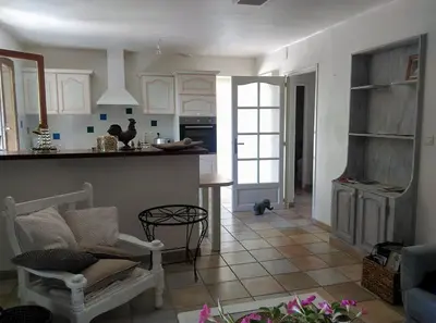 a kitchen and living room with a chair and a table at Gîte avec vue imprenable sur la Cité in Carcassonne