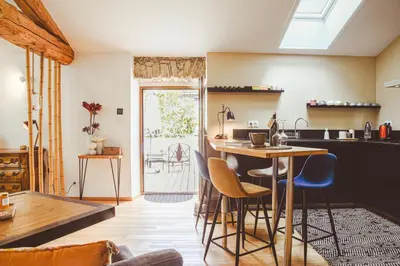 a kitchen with a table and chairs in a room at L'Autre Jardin, centre historique, calme, garage gratuit in Mirepoix