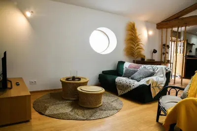 a living room with a couch and a table at L'Autre Jardin, centre historique, calme, garage gratuit in Mirepoix