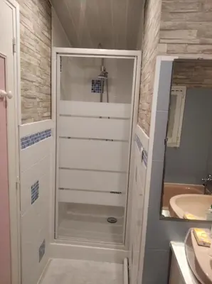 a bathroom with a walk in shower next to a sink at Charmante chambre d'hôte in Sigean