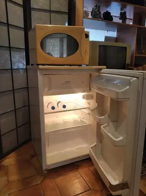 an open refrigerator with a microwave on top of it at Charmante chambre d'hôte in Sigean