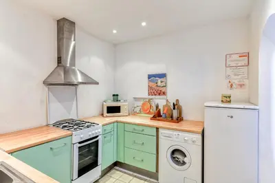 a kitchen with green cabinets and a washer and dryer at Domaine de Parazols in Fabrezan