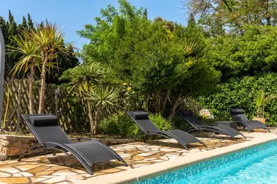 a group of chairs sitting next to a swimming pool at Domaine de Parazols in Fabrezan