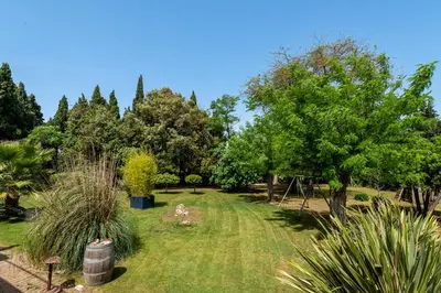 a garden with trees and grass and a playground at Domaine de Parazols in Fabrezan