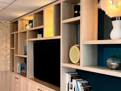 a library with wooden shelves and a tv at The Originals City, Hôtel Le Puech, Narbonne in Narbonne