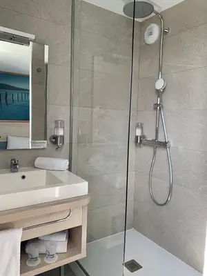 a bathroom with a shower and a sink at The Originals City, Hôtel Le Puech, Narbonne in Narbonne