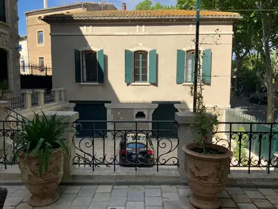 a house with a car parked in front of a fence at Château Tallavignes in Fabrezan