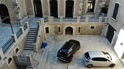 two cars parked in front of a building at Château Tallavignes in Fabrezan
