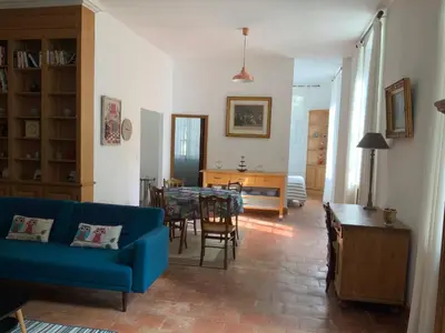 a living room with a blue couch and a table at Château Tallavignes in Fabrezan