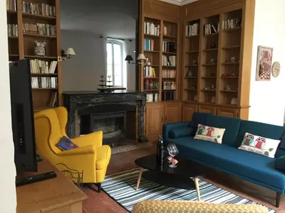 a living room with a blue couch and yellow chairs at Château Tallavignes in Fabrezan