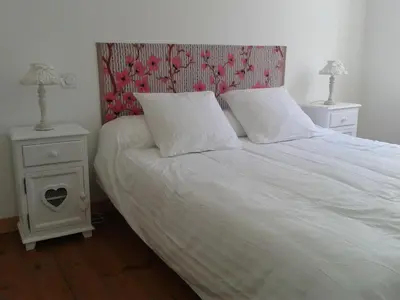 a bedroom with a white bed with two night stands at Chez Clémentine in Montolieu