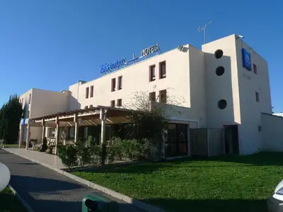 a white building with a sign on top of it at ibis budget Narbonne Sud A9/A61 in Narbonne