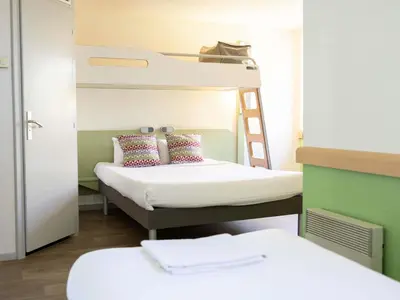 a bed with a book and a pair of sandals on it at ibis budget Narbonne Sud A9/A61 in Narbonne
