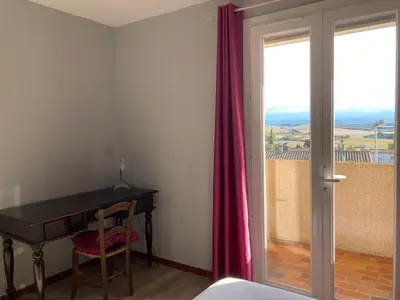 a bedroom with a desk and a sliding door with a window at 37 au soleil in Montréal