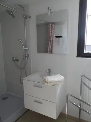 a white bathroom with a sink and a shower at 37 au soleil in Montréal