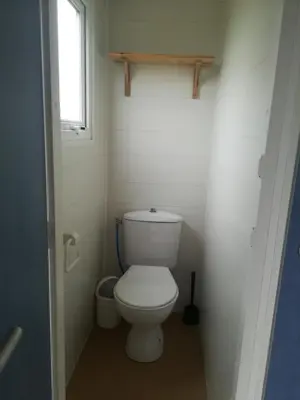 a small bathroom with a toilet with a window at Les chalets de Bes 