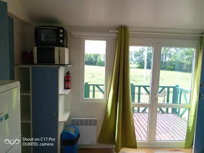 a kitchen with a sliding glass door to a deck at Les chalets de Bes 