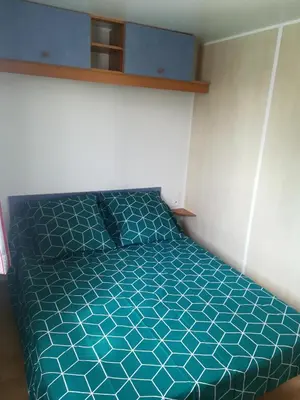 a bedroom with a bed with a blue comforter at Les chalets de Bes Le Montagnol in Lacombe