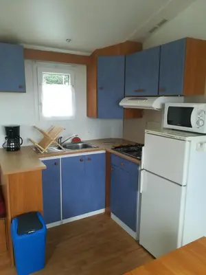 a kitchen with blue cabinets and a white refrigerator at Les chalets de Bes Le Montagnol in Lacombe