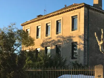 a building with a fence in front of it at villa du chai studio pyrénées in Lézignan-Corbières