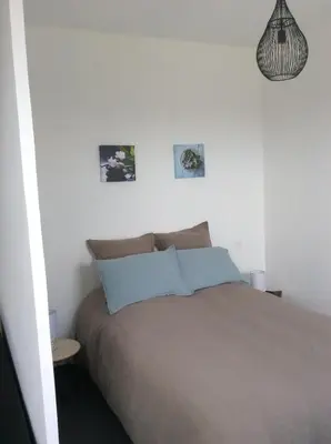 a bedroom with a bed and two pictures on the wall at villa du chai studio pyrénées in Lézignan-Corbières