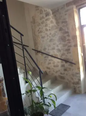 a staircase in a room with a stone wall at villa du chai studio pyrénées in Lézignan-Corbières