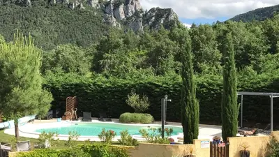 a swimming pool in front of a mountain at Le Jardin des Gorges in Belvianes-et-Cavirac