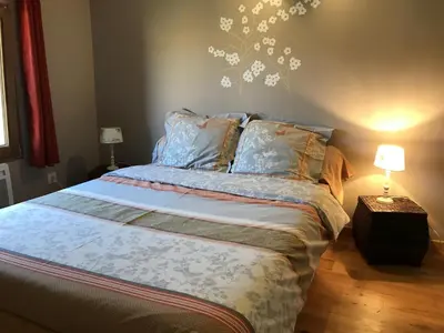 a bedroom with a bed with a flower mural on the wall at Le Jardin des Gorges in Belvianes-et-Cavirac