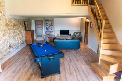 a living room with a ping pong table and stairs at La Barbacane in Sigean