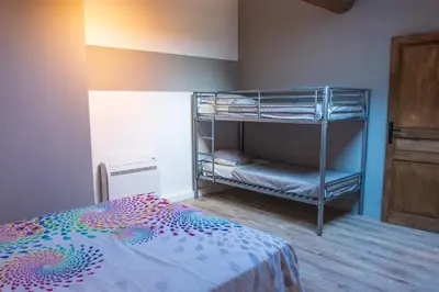 a bedroom with a bunk bed with a colorful bedspread at La Barbacane in Sigean