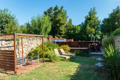 a garden with chairs and a stone wall at La Barbacane in Sigean