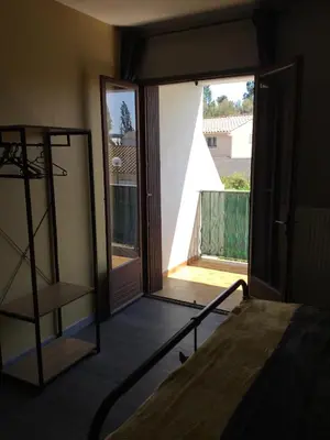 a room with a balcony with a bed and a window at Marina in Narbonne