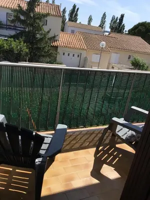 a patio with two chairs and a fence at Marina in Narbonne