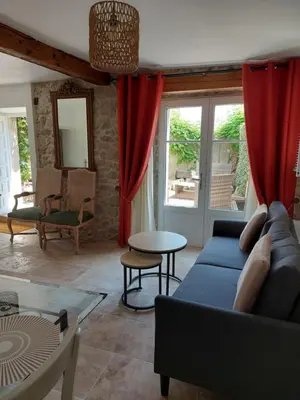 a living room with a blue couch and red curtains at Le Logis des Remparts à l'intérieur de la Cité médiévale, Jardin privé, Parking inclus in Carcassonne
