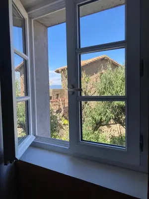 an open window with a view of a tree at Le Logis des Remparts à l'intérieur de la Cité médiévale, Jardin privé, Parking inclus in Carcassonne