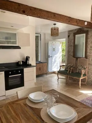 a kitchen with a table with two plates on it at Le Logis des Remparts à l'intérieur de la Cité médiévale, Jardin privé, Parking inclus in Carcassonne