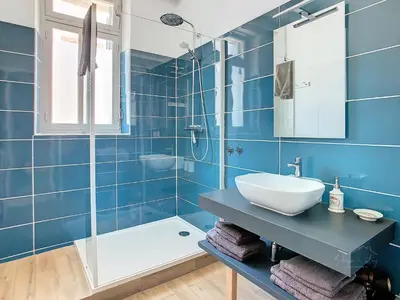 a blue bathroom with a sink and a shower at Apartment La Terasse in Carcassonne