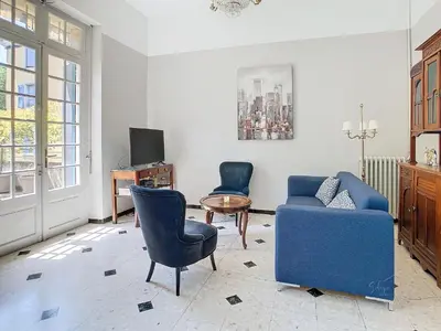 a living room with two chairs and a blue couch at Apartment La Terasse in Carcassonne