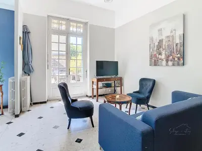 a living room with a couch and chairs and a tv at Apartment La Terasse in Carcassonne