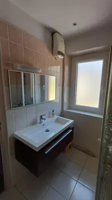 a bathroom with a sink and a mirror and a window at Canta aoussel in Moussoulens