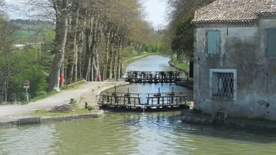 a river with tables and chairs on it at Canta aoussel in Moussoulens